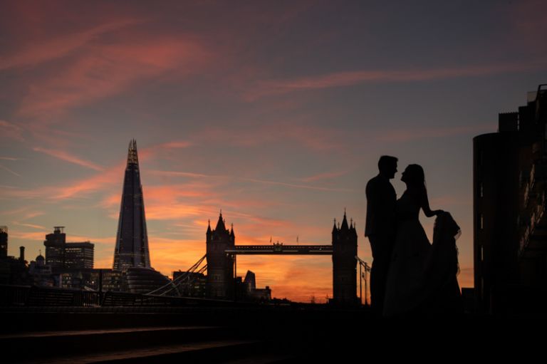 Bride and groom silhouettes with London skyline behind. The Shard and Tower Bridge